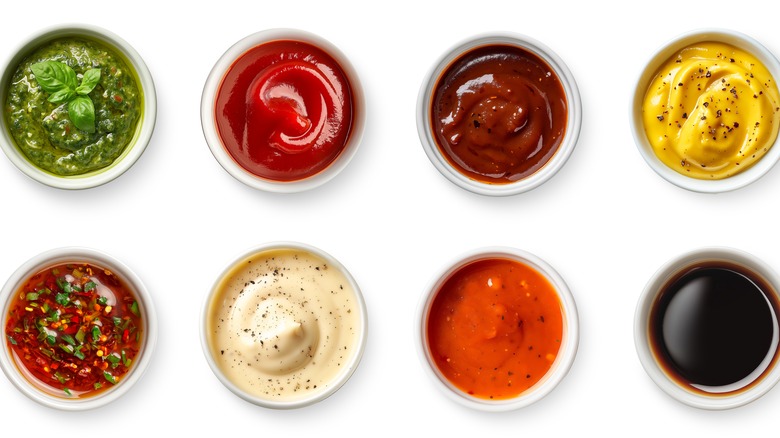 Différentes sauces dans des ramequins sur fond blanc