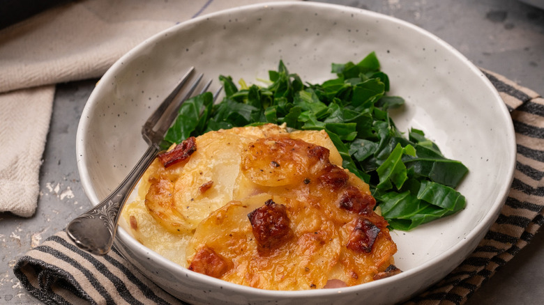 gratin de pommes de terre dans un bol avec des légumes verts