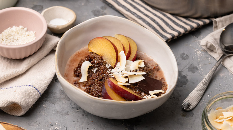 Bol de quinoa pour le petit-déjeuner, avec prunes et chocolat noir