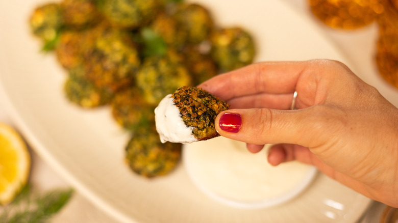 boulettes de quinoa aux épinards et aux herbes trempées dans une sauce 