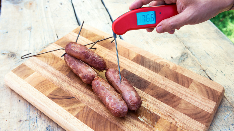 thermomètre vérifiant la température des saucisses