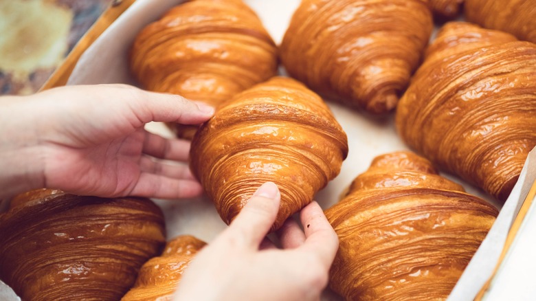 Personne prenant un croissant frais 