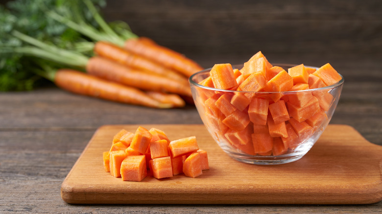 Carottes coupées en dés sur une planche à découper