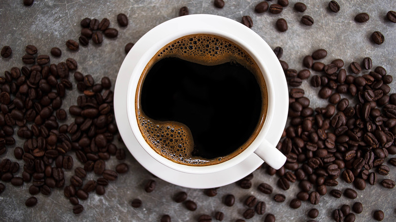 Une tasse de café entourée de grains de café