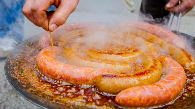 saucisse piquée à la main avec un cure-dent