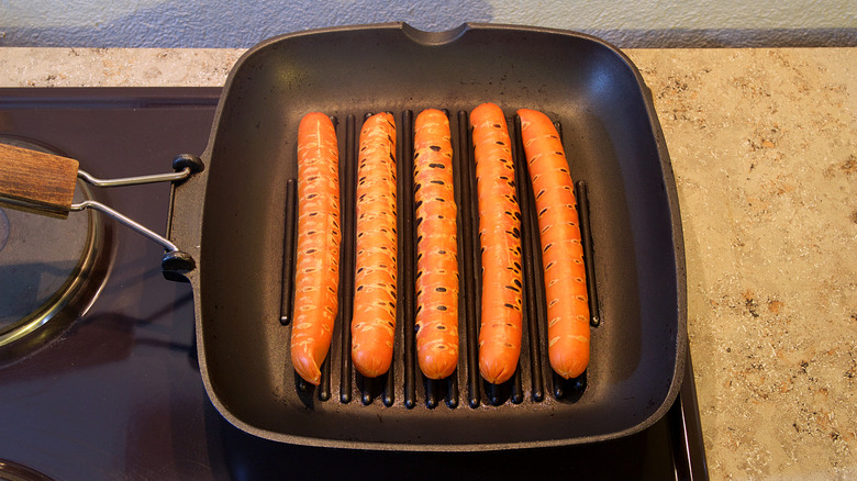 cuisson de hot-dogs sur une plaque chauffante