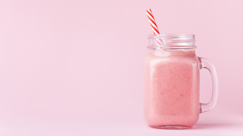 Smoothie rose dans un verre avec paille