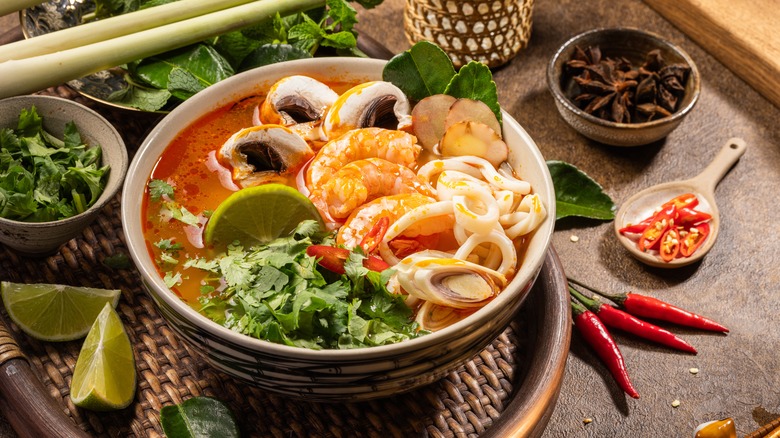 Soupe Tom Yum entourée d'ingrédients 