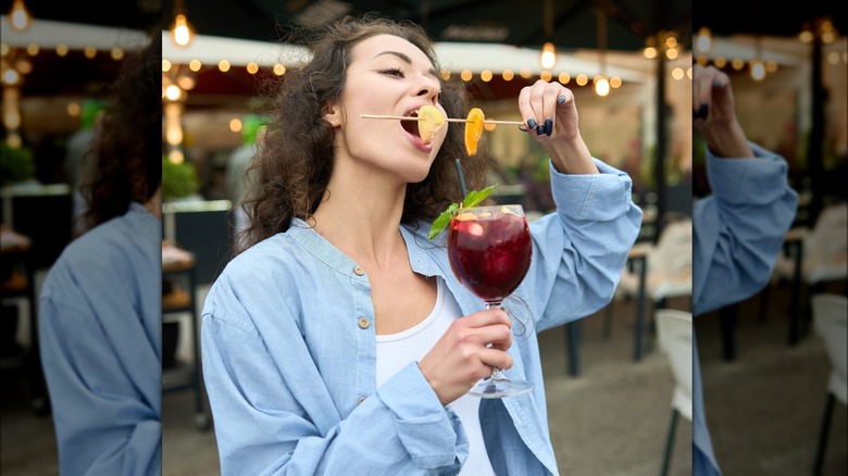 femme mangeant une brochette de fruits