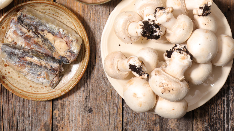 assiettes de champignons crus et de sardines en conserve