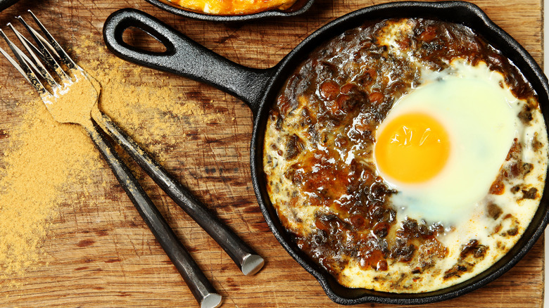 œuf cuit dans une poêle de dal sur une table en bois