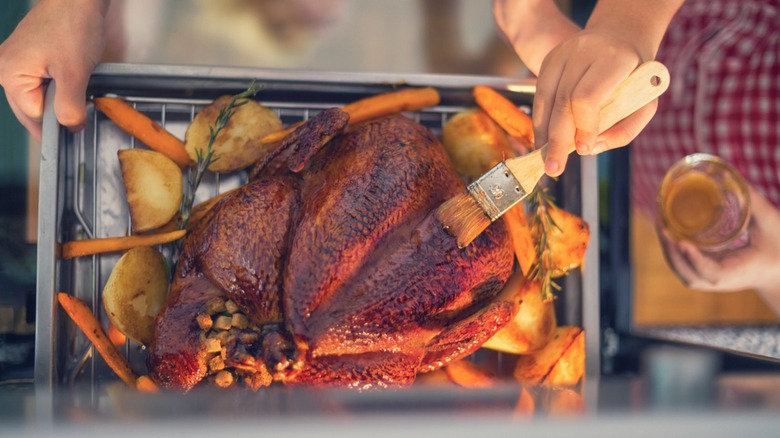 Badigeonner le poulet sur la poêle