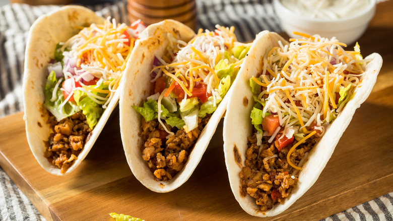 tacos au bœuf dans des tortillas à la farine sur une planche de bois