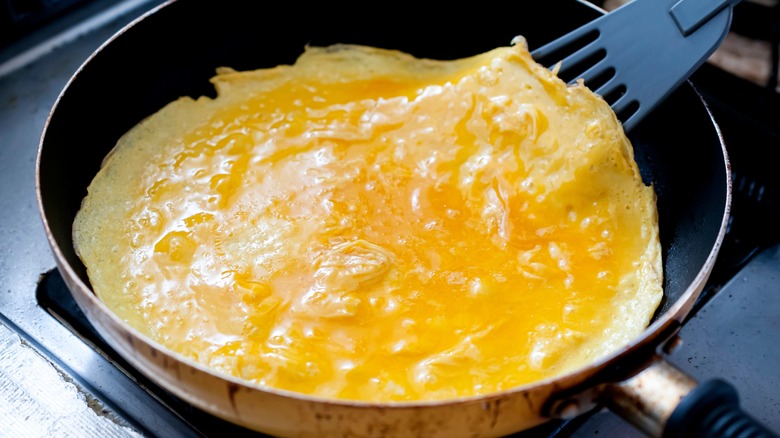 cuisson d'omelette à la poêle avec une spatule