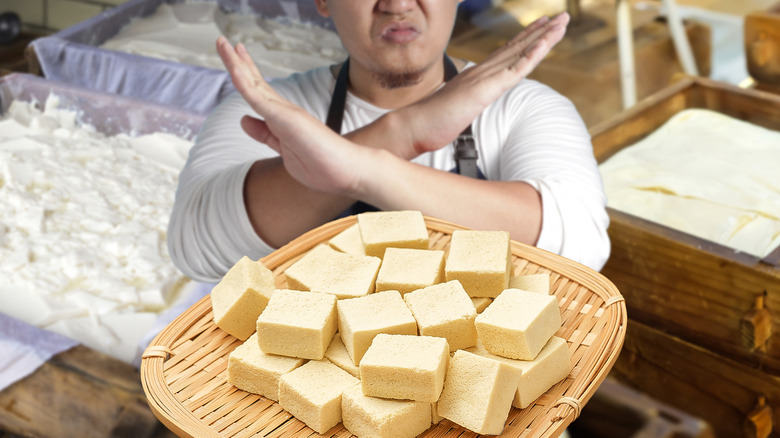 Homme avec du tofu coupé en cubes