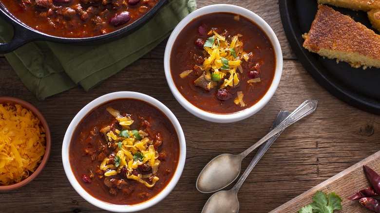 Des bols de chili à côté du pain de maïs