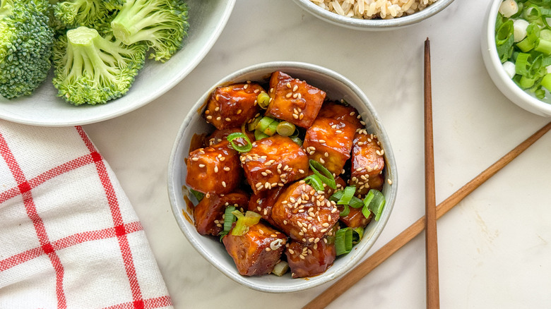 petit bol de tofu sriracha à côté de bols de légumes