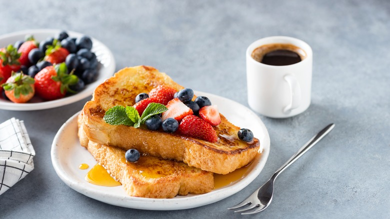 Pain perdu sur assiette avec tasse à café et fruits