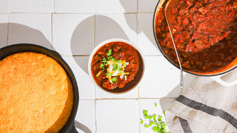 Bol de chili, pot de chili et pain de maïs sur le comptoir