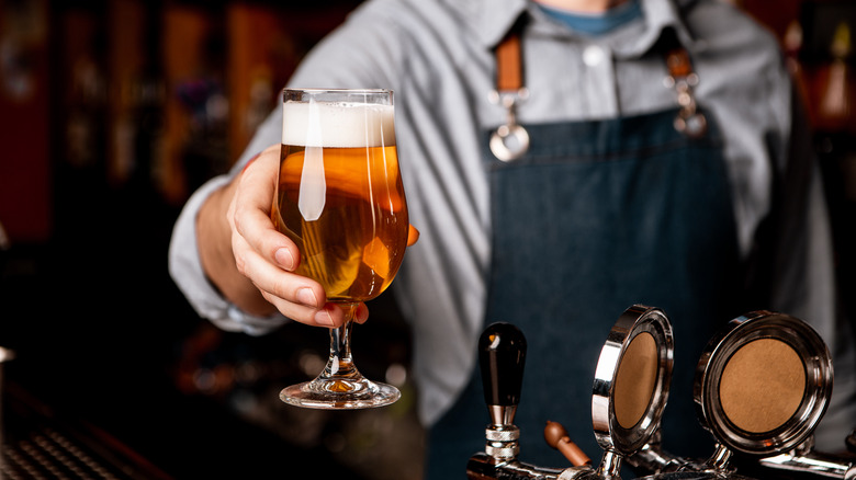 Un barman passe de la bière à un client