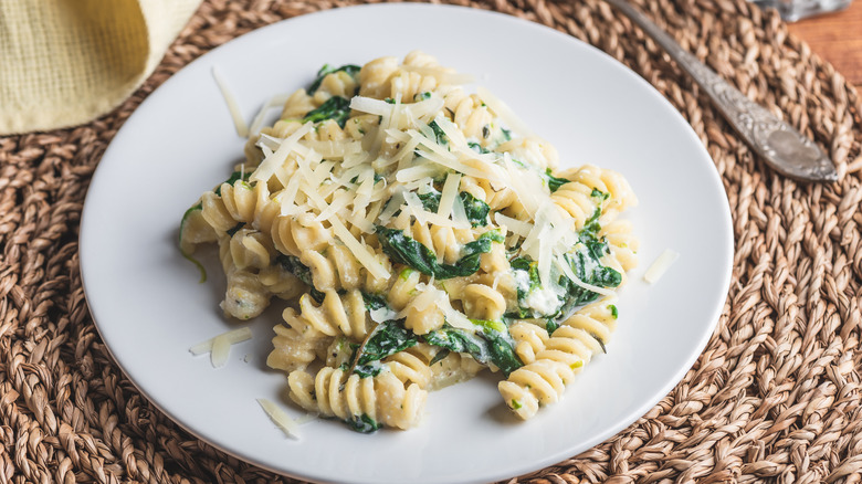 pâtes fusilli aux épinards, parmesan et sauce à la crème sur une assiette