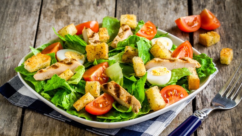 Salade de laitue, tomates, œufs et poulet avec croûtons