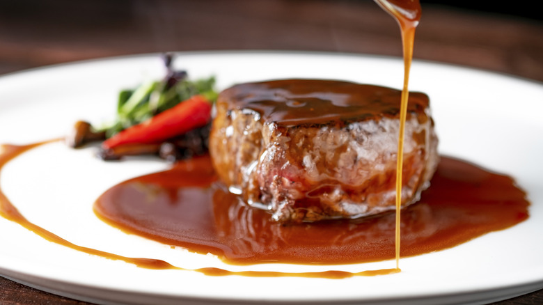 verser la sauce bordelaise sur une assiette de steak