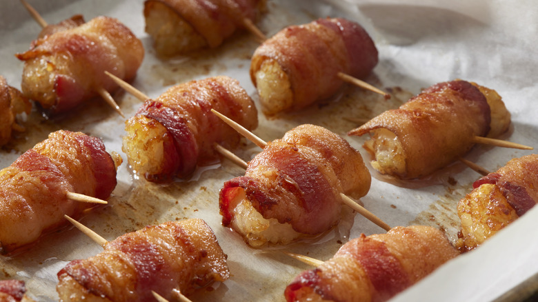 des tater tots enveloppés de bacon sur une plaque à pâtisserie