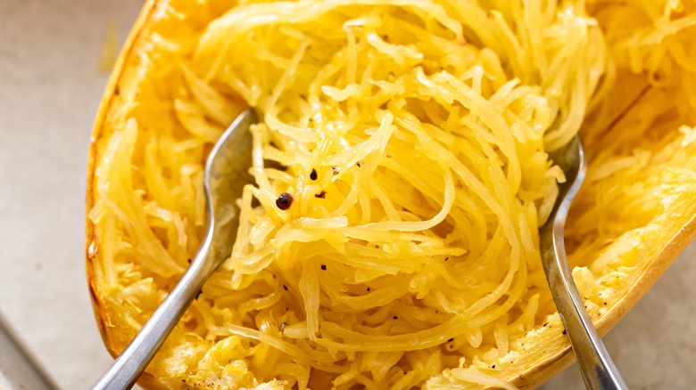 Gros plan sur des fourchettes qui gonflent des spaghettis de courge cuits