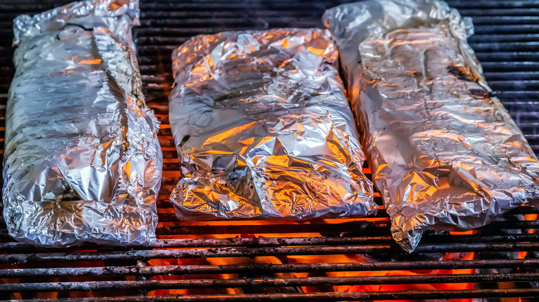 Paquets de papier d'aluminium sur le gril