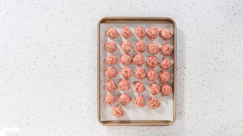 Des boulettes de viande uniformes sur une plaque à pâtisserie