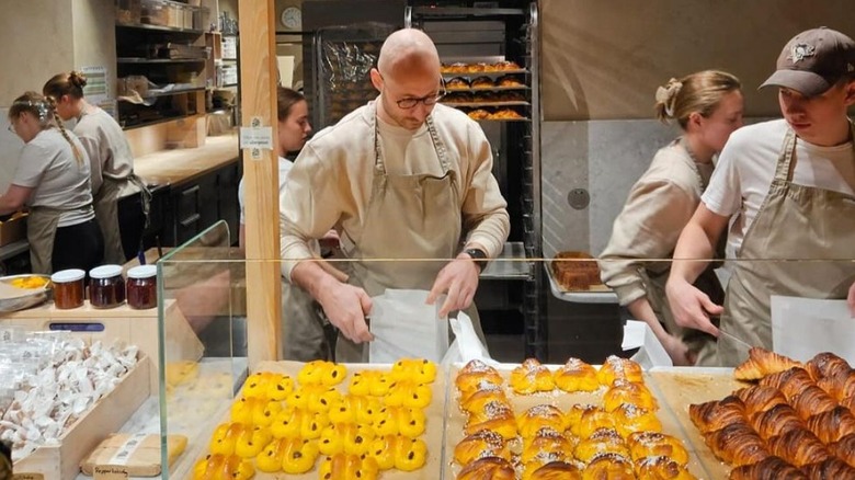 personnel de la boulangerie organisant des petits pains et des croissants