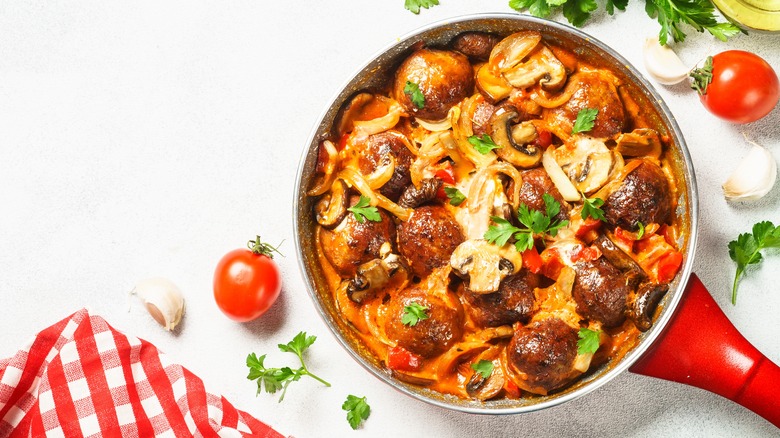 Boulettes de viande à la poêle entourées de tomates 