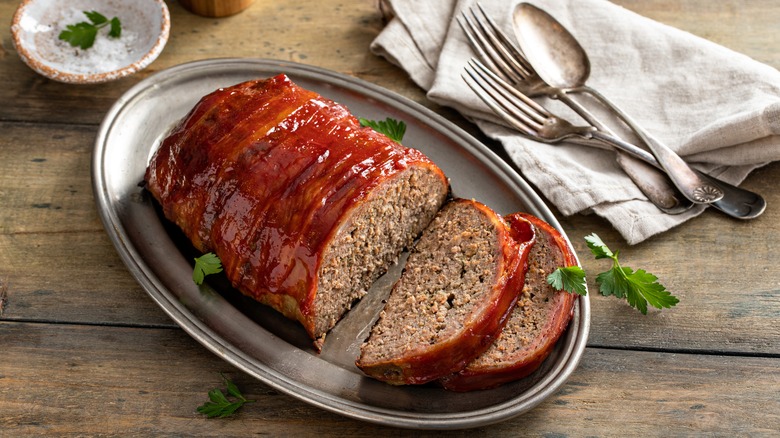 pain de viande en deux tranches avec des ustensiles