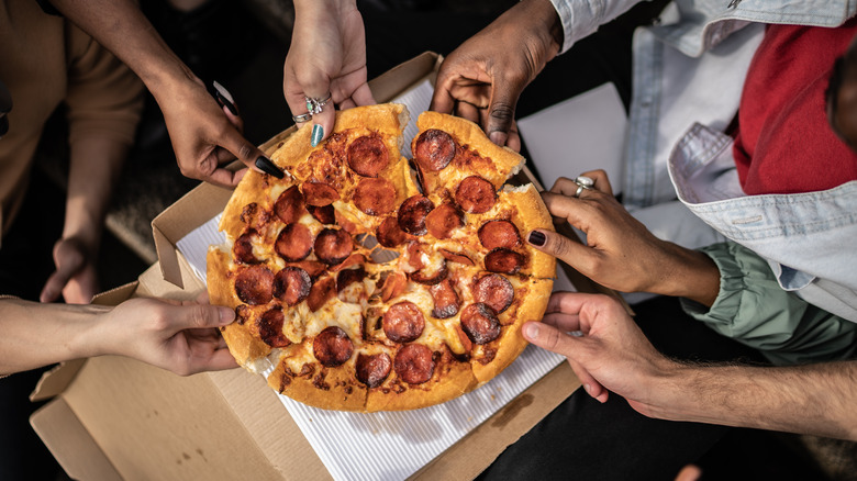 Mains saisissant des tranches de pizza