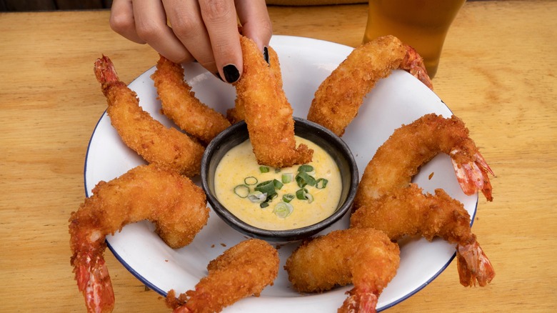 tremper les crevettes frites dans la sauce