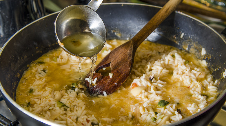 louche de bouillon ajoutée au risotto