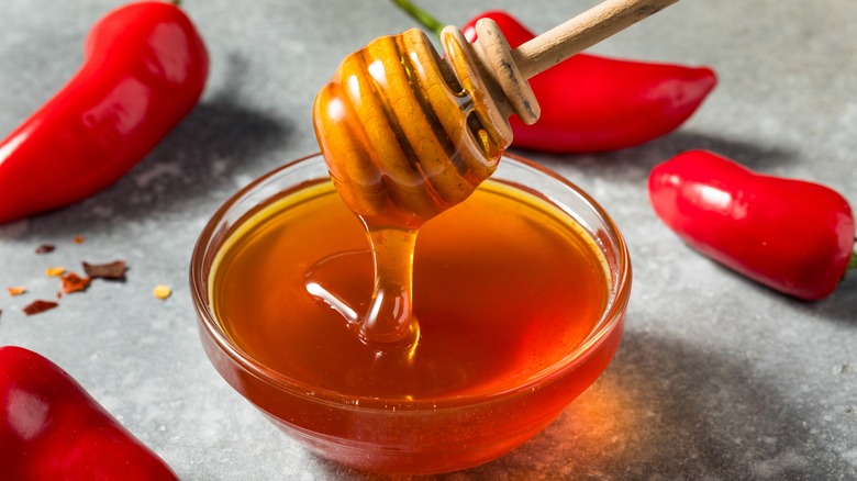 miel dans un bol entouré de poivrons rouges