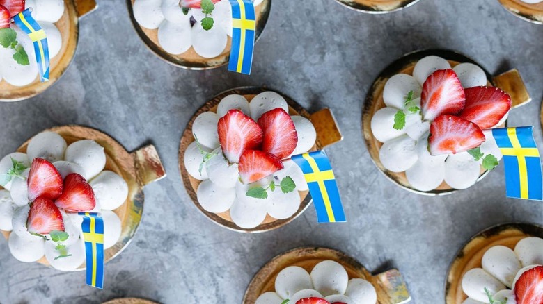 tartelettes aux fraises avec des drapeaux suédois sur une surface grise