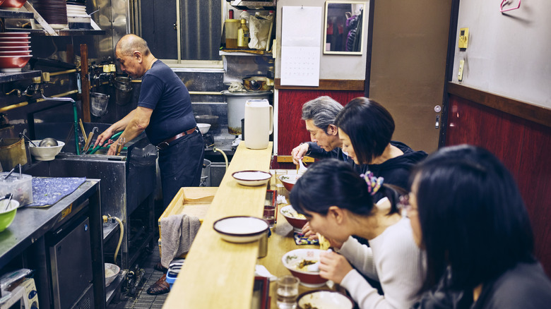 Clients au comptoir du restaurant ramen