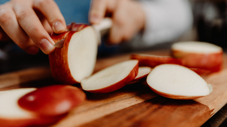 Personne coupant une pomme