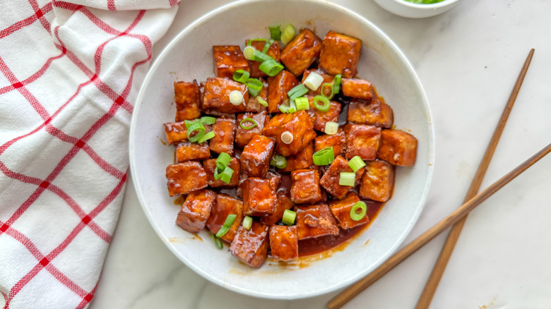 tofu épicé dans un bol avec des baguettes