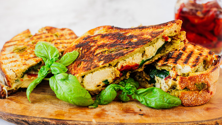 trois sandwichs panini au poulet sur une planche à découper