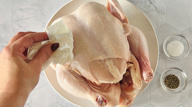 Sécher le poulet entier avec du papier à la main