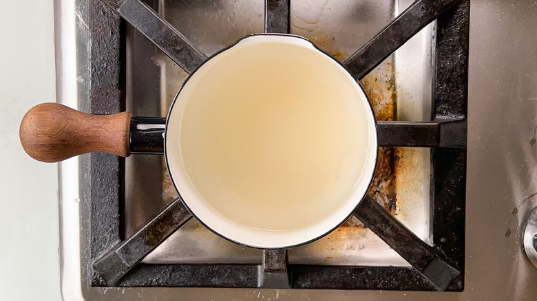 Cuisson de l'eau et du sucre dans une casserole sur la cuisinière