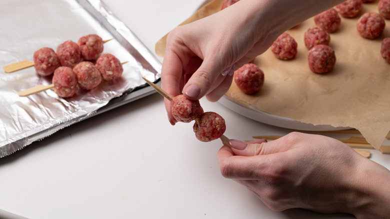 placer des boulettes de viande sur une brochette