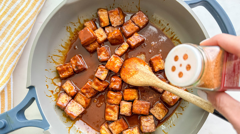 ajouter de la poudre de sriracha à la poêle de tofu en sauce