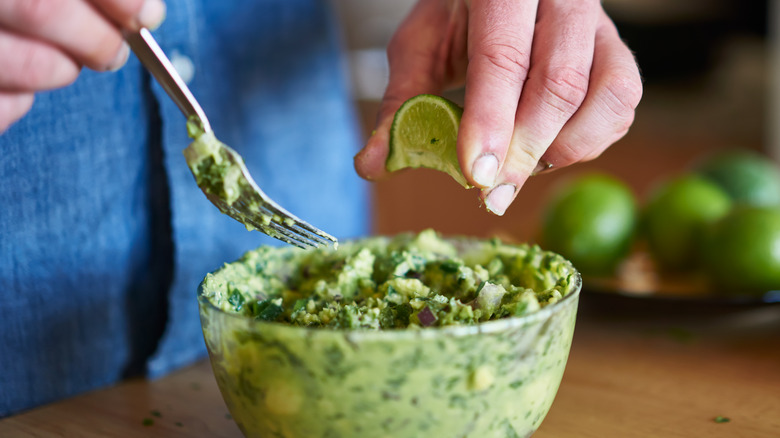 Gros plan sur des mains qui préparent du guacamole