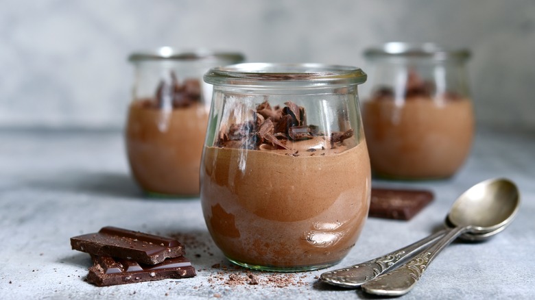 Contenants de mousse au chocolat avec des cuillères à proximité