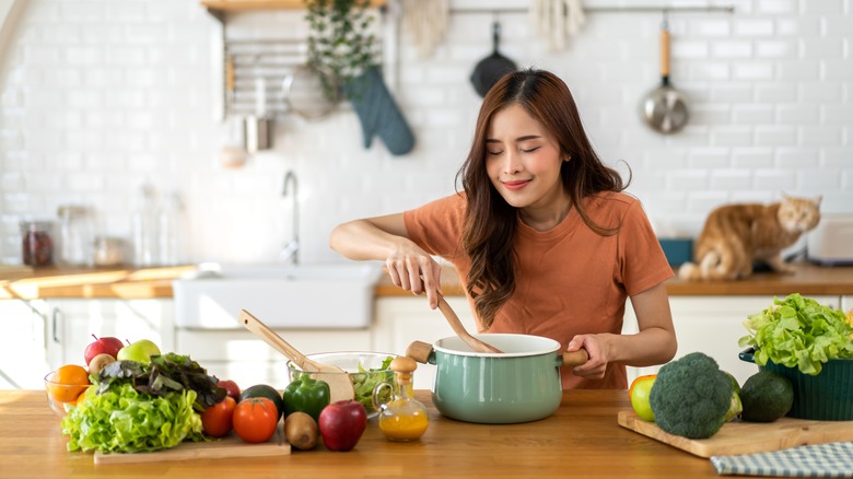 femme sentant une marmite de soupe